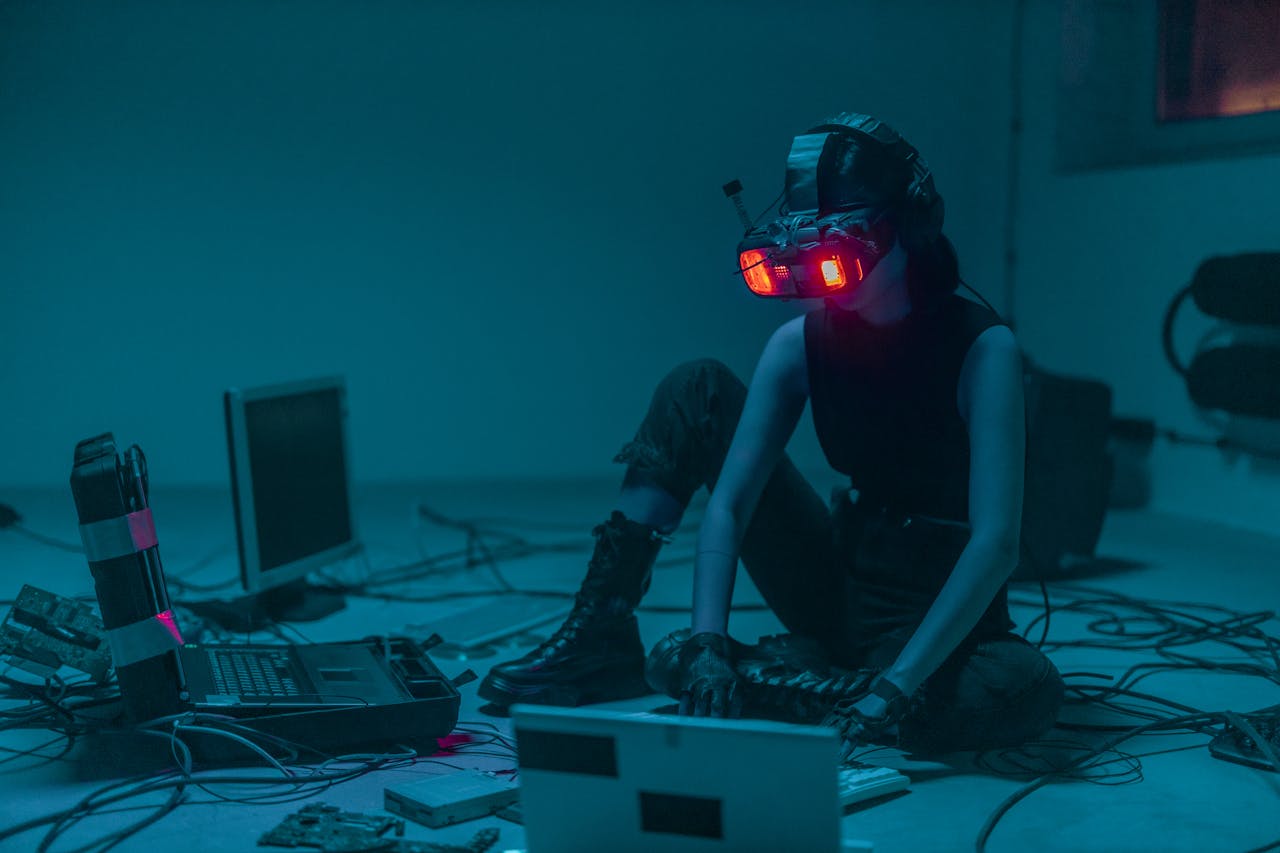 who-we-are A person in a VR headset hacking in a moody, neon-lit environment.